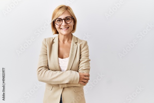 Middle age blonde business woman standing over isolated background happy face smiling with crossed arms looking at the camera. positive person.