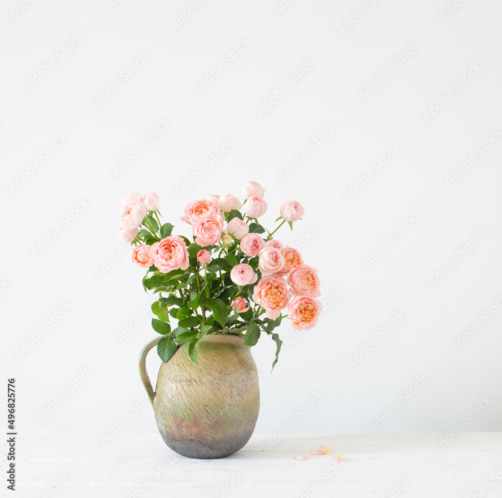 bouquet of peony roses in ceramic jug on white background bouquet of peony roses in ceramic jug on white background