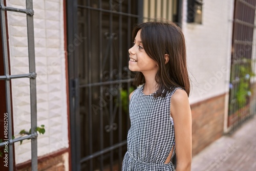 Young hispanic girl smiling outdoor at the town
