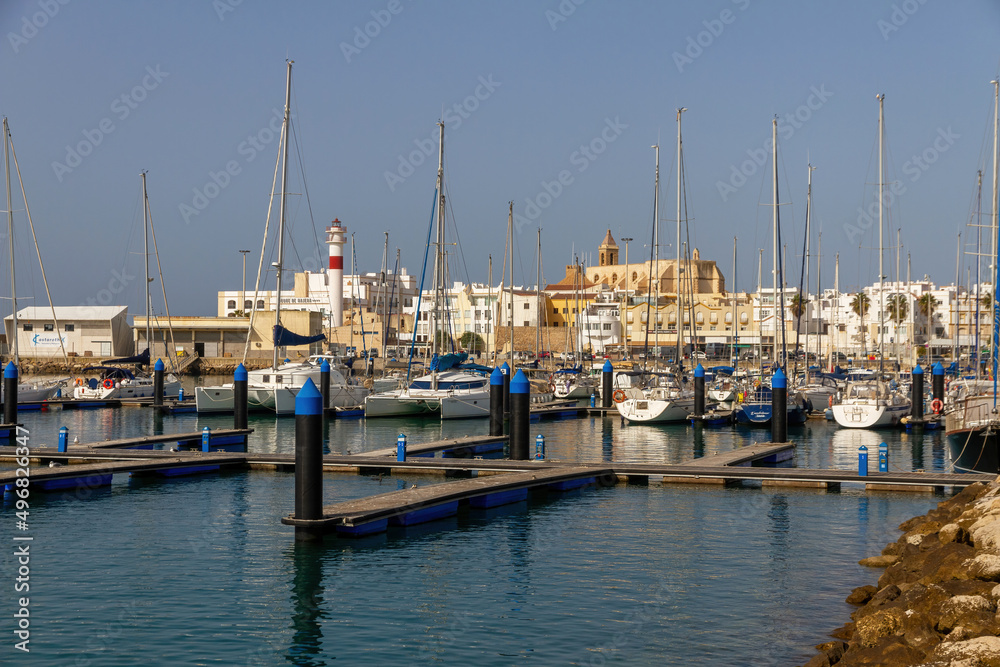 Obraz premium View of the town of Rota from the marina with boats and the lighthouse, Cadiz, Spain