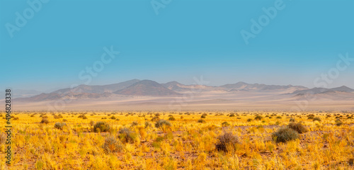 Panoramic view of desert plains in Namibia Africa with hills and mountains in the background