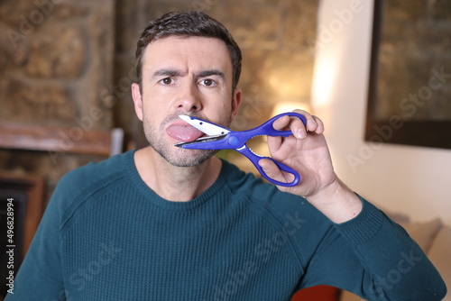 Man cutting tongue with scissors photo