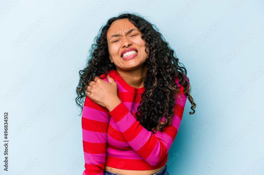 Young hispanic woman isolated on blue background having a shoulder pain. Young hispanic woman isolated on blue background having a shoulder pain.
