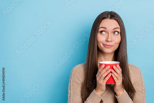 Portrait of attractive pensive sly cheery girl drinking latte thinking copy blank space isolated over bright blue color background © deagreez