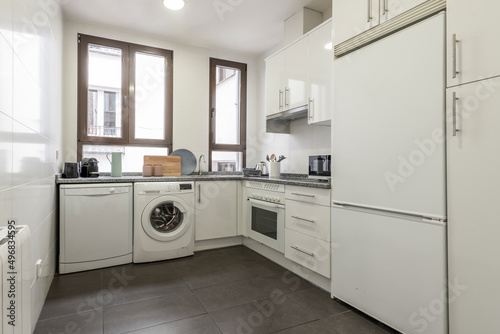 White kitchen with matching appliances, gray granite counter top and small appliances on the counter