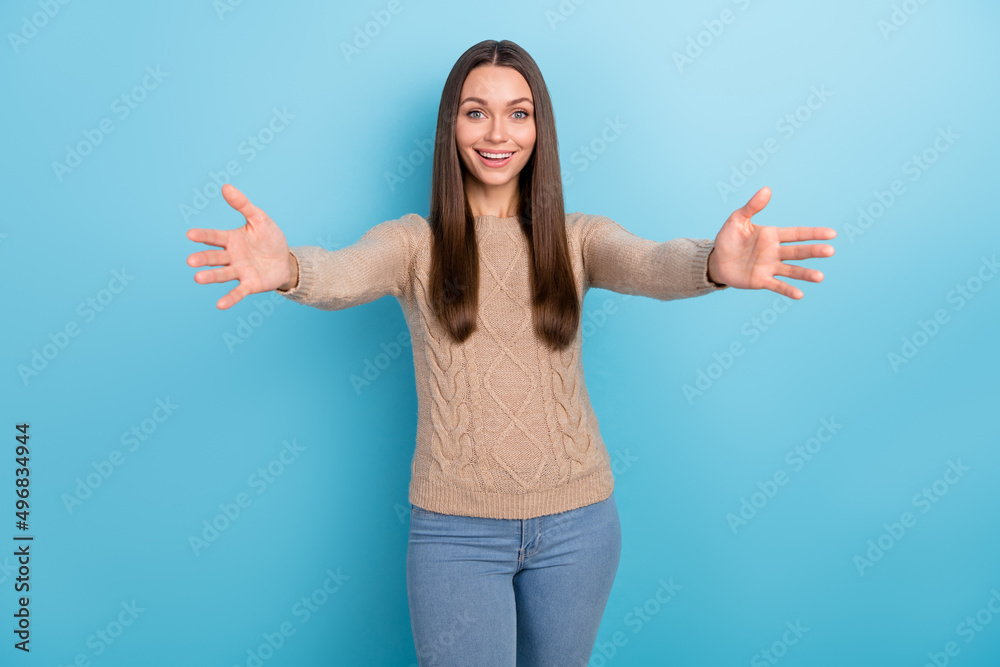 Photo of glad friendly lady stretch hands invite hug you wear beige sweater isolated blue color background Photo of glad friendly lady stretch hands invite hug you wear beige sweater isolated blue color background
