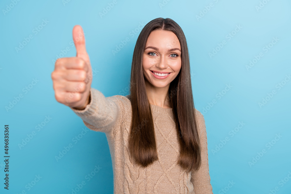 Photo of promoter lady raise thumb up recommend approve choice wear beige sweater isolated blue color background Photo of promoter lady raise thumb up recommend approve choice wear beige sweater isolated blue color background