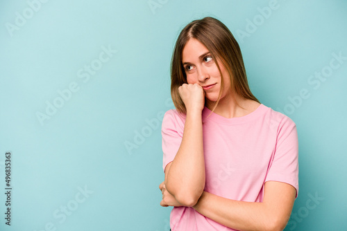 Young caucasian woman isolated on blue background who feels sad and pensive, looking at copy space.