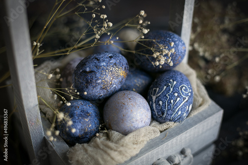 Dyed Easter eggs with marble stone effect painted with natural dye carcade tea from hibiscus flowers in wooden box.   photo