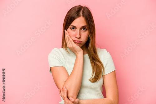 Young caucasian woman isolated on pink background who is bored, fatigued and need a relax day.