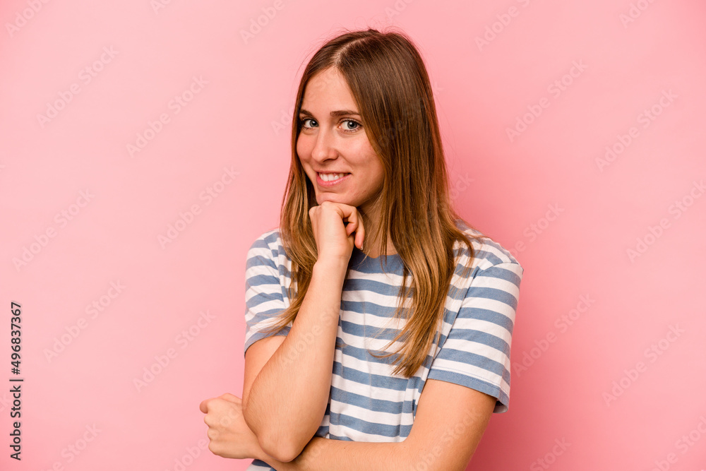 Young caucasian woman isolated on pink background smiling happy and confident, touching chin with hand.