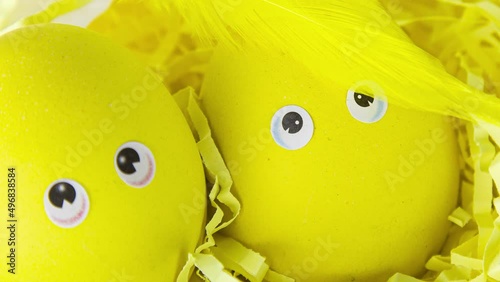 Decorative basket with yellow eggs decorated with feathers in the sun