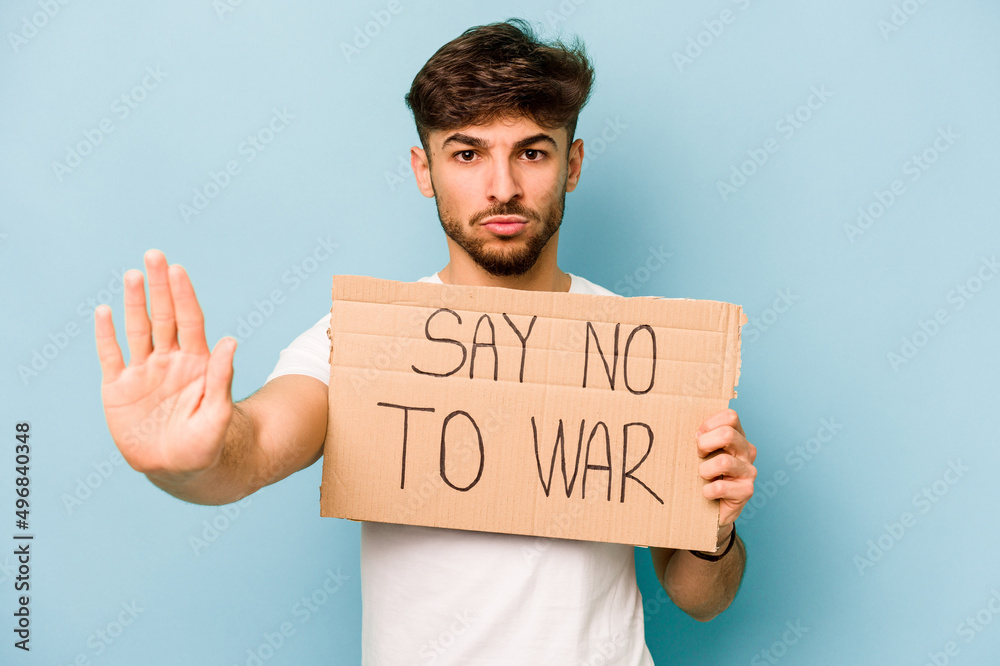 Young hispanic man holding say no war placard isolated on white background Young hispanic man holding say no war placard isolated on white background