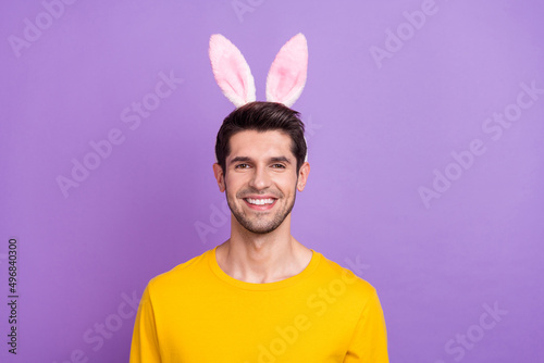 Portrait of handsome cheerful carefree playful childish man with bunny headband isolated on violet color background