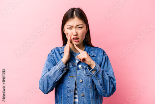 Young Chinese woman isolated on pink background having a strong teeth pain, molar ache.