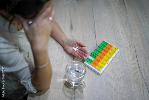 young woman preparing medication at home at the table exhausted, tired