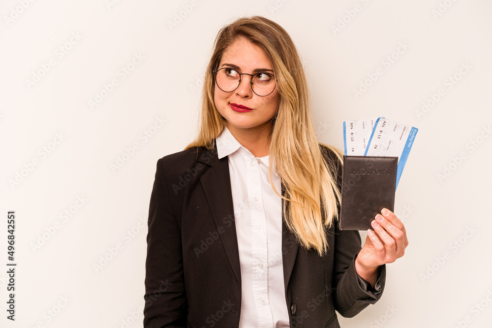 Young business caucasian woman holding a passport isolated on white background confused, feels doubtful and unsure. Young business caucasian woman holding a passport isolated on white background confused, feels doubtful and unsure.