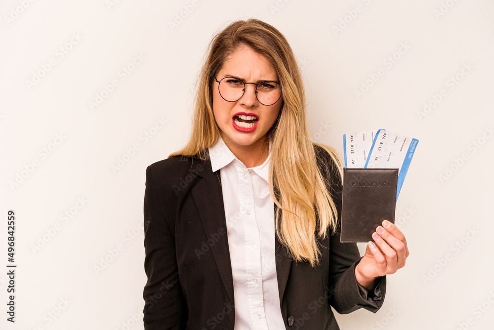 Young business caucasian woman holding a passport isolated on white background screaming very angry and aggressive.