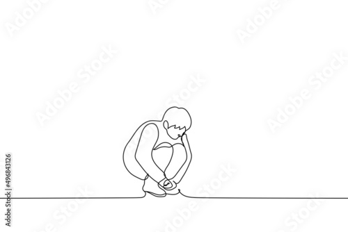 man squatting cowering - one line drawing vector. concept of loneliness, abandonment, outsider photo