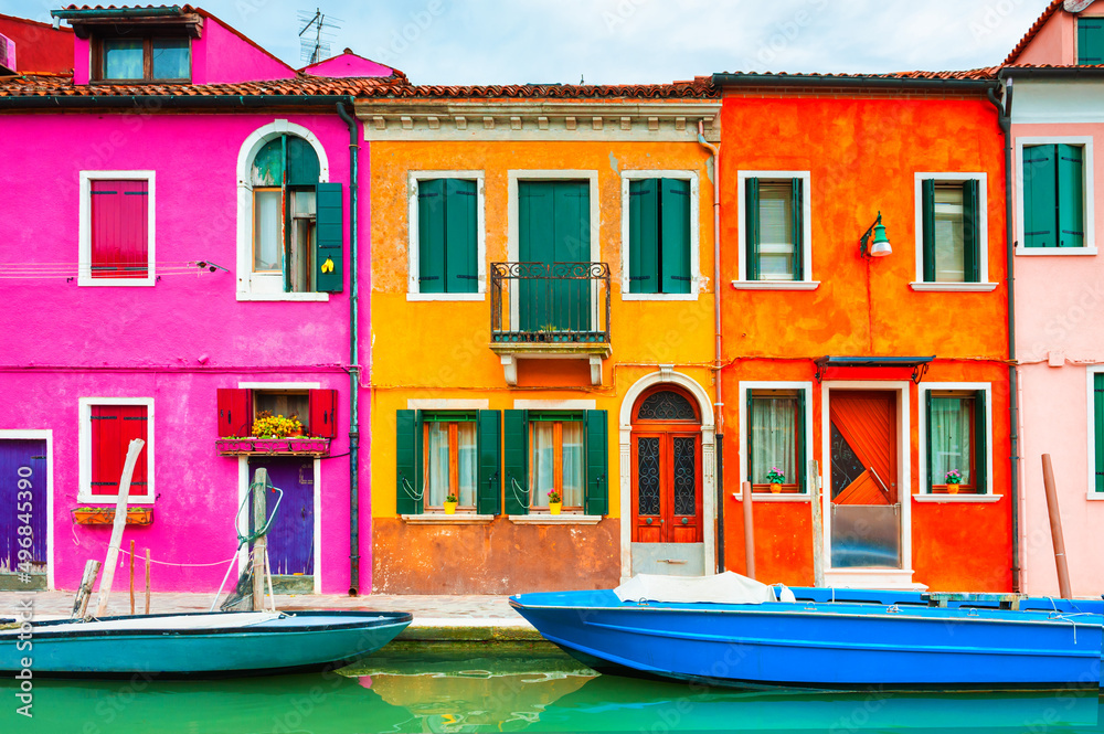 Colorful architecture and canal with boats in Burano island, Venice, Italy. Famous travel destination. Beautiful european cityscape