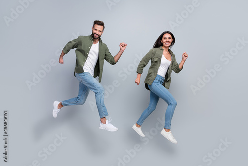 Full length photo of lady guy spouses jump run fast speed bargain isolated over grey color background