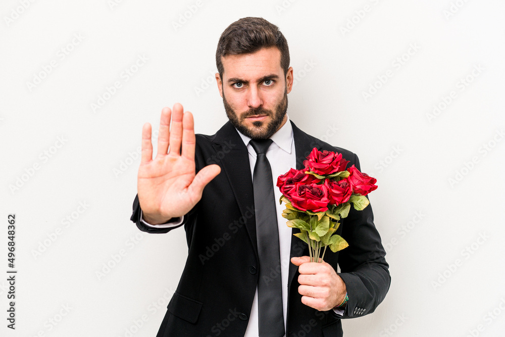 Young caucasian man holding a bouquet of flowers isolated on white background standing with outstretched hand showing stop sign, preventing you. Young caucasian man holding a bouquet of flowers isolated on white background standing with outstretched hand showing stop sign, preventing you.