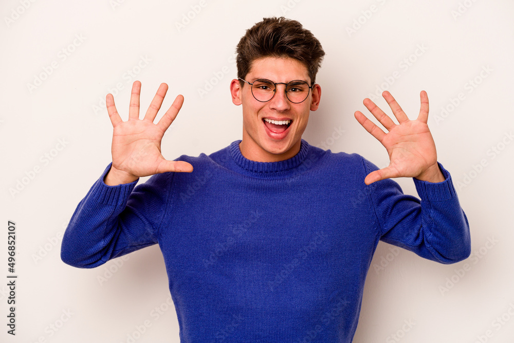 Naklejka premium Young caucasian man isolated on white background showing number ten with hands.