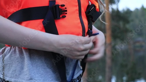 A person tying their life vest before going to ride a boat