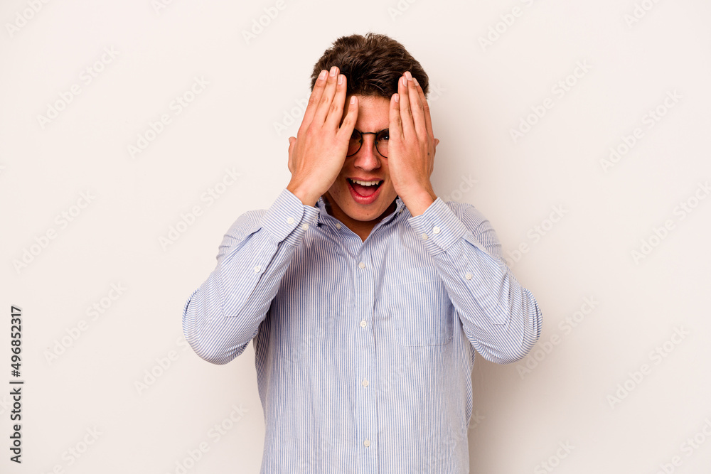 Young caucasian man isolated on white background having fun covering half of face with palm. Young caucasian man isolated on white background having fun covering half of face with palm.