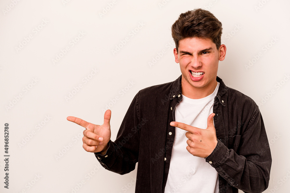 Young caucasian man isolated on white background pointing with forefingers to a copy space, expressing excitement and desire. Young caucasian man isolated on white background pointing with forefingers to a copy space, expressing excitement and desire.