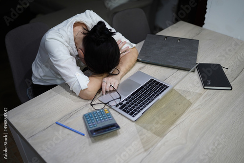 young woman working at home on computer, tired, exhausted