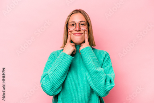 Young caucasian woman isolated on pink background doubting between two options.