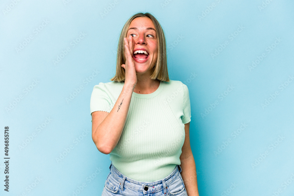 Young caucasian woman isolated on blue background shouting excited to front. Young caucasian woman isolated on blue background shouting excited to front.