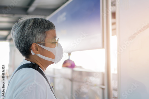 Asian traveler senior woman wearing face mask at gate metro or subway train feeling alone while COVID-19 virus disease coronavirus outbreak. New normal healthcare in life prevent pandemic epidemic