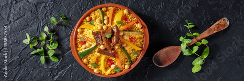Meat and vegetable couscous panorama. Traditional Moroccan dish, overhead flat lay shot on a dark background photo