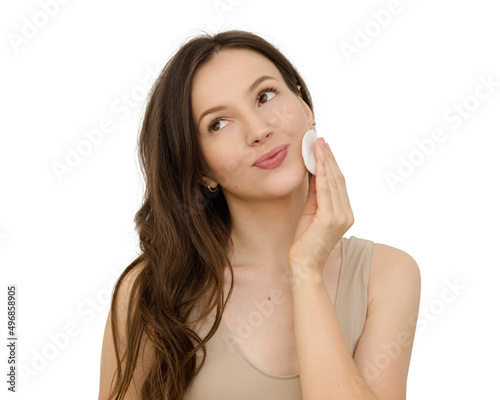young beautiful woman wipes her face with a cotton pad
