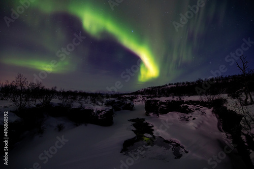 Scenic view of Aurora's Flow Over Sweden's Lake Tornetrask in Abisko village in Sweden photo