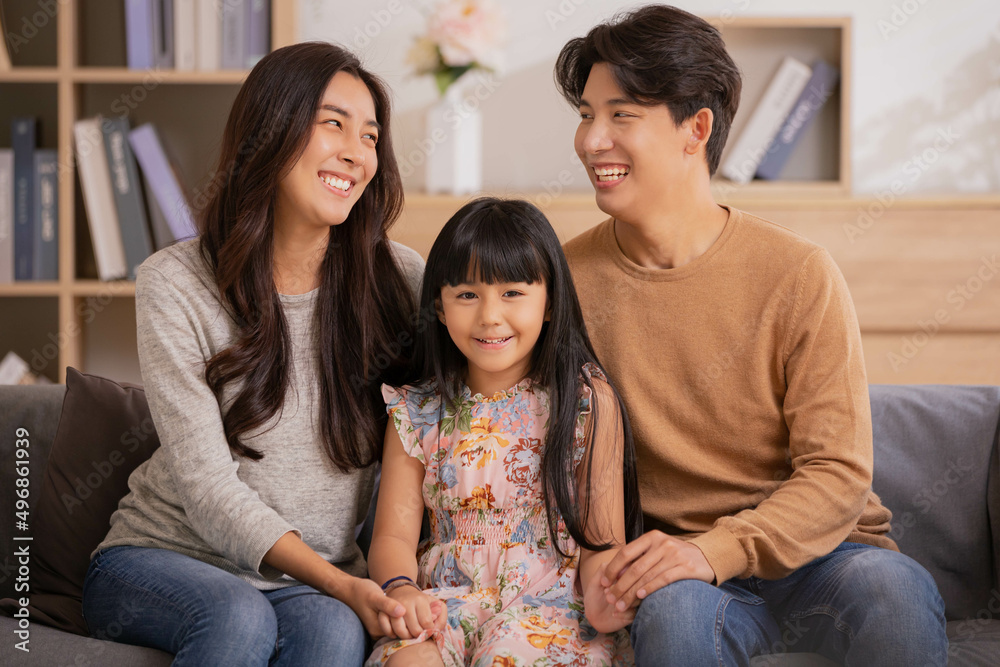 Happy parents and little daughter having fun enjoying spending leisure time together at home sitting on sofa. Happy parents and little daughter having fun enjoying spending leisure time together at home sitting on sofa.