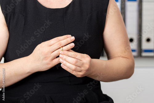 Hands of caucasian female who is about to taking off her wedding ring at the lawyer's office © cunaplus