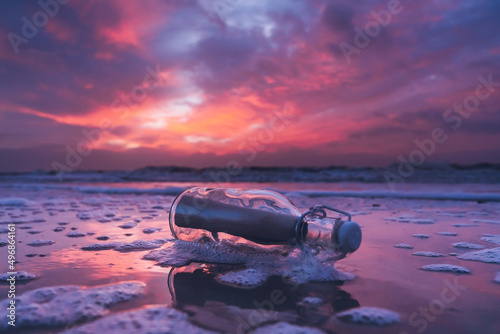 Beautiful cloudy sunset in Denmark at the beach with message in a bottle