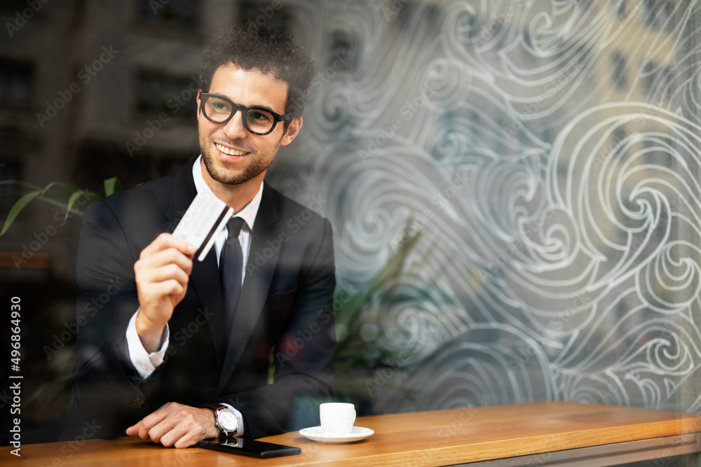 Handsome businessman enjoy in fresh coffee. Young man with credit card and phone Handsome businessman enjoy in fresh coffee. Young man with credit card and phone