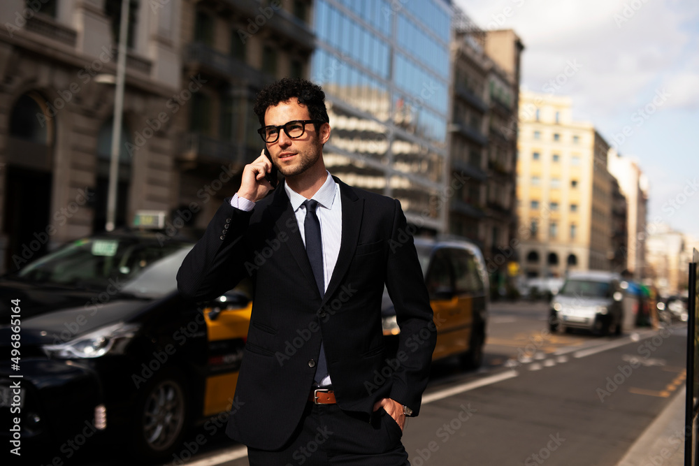 Handsome businessman using the phone. Young elegance man outdoors..