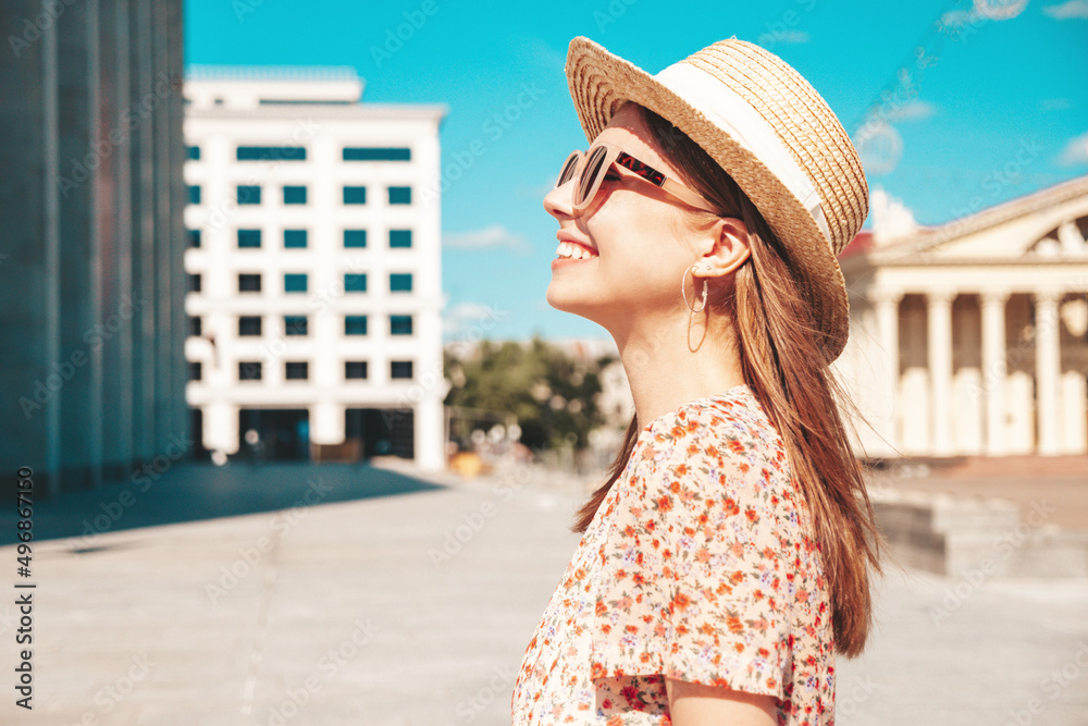 Young beautiful smiling hipster woman in trendy summer clothes. Sexy carefree woman posing on the street background at sunset. Positive model outdoors. Cheerful and happy in sunglasses and hat