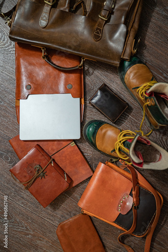 FlatLay still life set of vintage stylish leather items: brown shoes, a laptop, a notebook, two cases, a briefcase and a traveler's bag