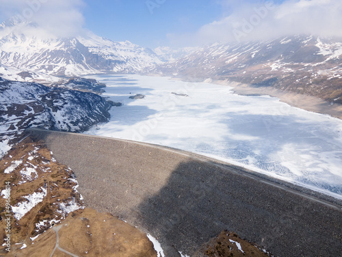 Frozen lake and dam with road in the mountains, Mont Cenis (Moncenisio), aerial drone view photo