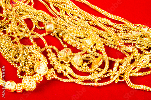 Set of gold necklace on red Velvet fabric.