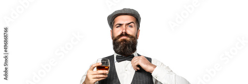 Degustation, tasting. Man with beard holds glass of brandy. Tasting and degustation concept. Bearded businessman in elegant suit with glass of whiskey. Sommelier tastes expensive drink