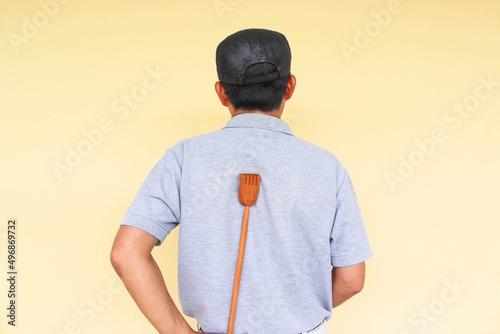 Man used wooden back scratcher for back itch therapy on cement wall background closeup. photo