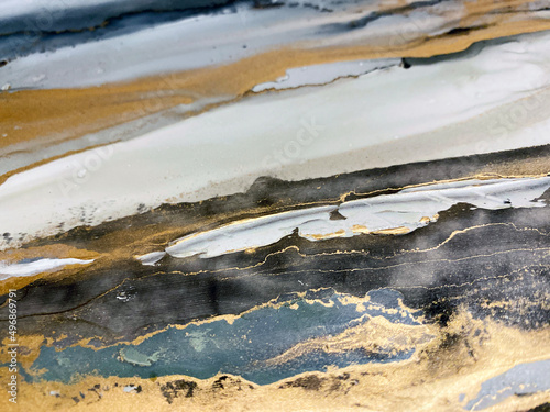 Abstract textured art with gold — black and white background with beautiful brush strokes made with alcohol ink, acrylic and golden paint. Fluid texture resembles oil painting and aquarelle.