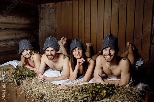 Shot of a group of friends smiling and looking at the camera lying down.